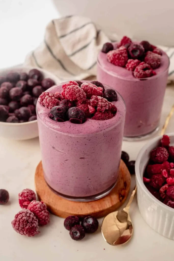 Vasos de smoothie proteico de frutos rojos con frambuesas y arándanos